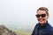 Smiling woman hiker poses at the Little Stony Man mountain overlook hike during a foggy spring day. Negative space, room for copy