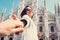 Smiling woman hold his boyfriend hand on Duomo di Milano background