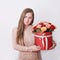 Smiling woman hold red gift box. Wall background. Concept of Valentine or Happy birthday. Bright and gorgeous bouquet of lovely