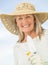 Smiling Woman Holding Gardening Equipment Against Sky