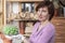 Smiling woman holding in the hands in glove big cactus Gymnocalycium