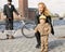 Smiling woman holding laughing kid wearing tweed clothes in front of Stockholm City Hall