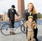 Smiling woman holding laughing kid wearing tweed clothes in front of Stockholm City Hall