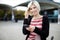 Smiling Woman Holding Mobile Phone Outside Railroad Station