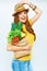 Smiling woman holding paper bag with green vegan food