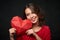 Smiling woman holding red polygonal heart shape