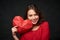 Smiling woman holding red polygonal heart shape