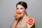 Smiling woman holding two grapefruits in hands