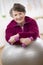 Smiling woman holding weights and laying on the exercising ball