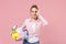 Smiling woman housewife in checkered shirt hold basin with detergent bottles washing cleansers doing housework isolated