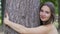 Smiling woman hugs a tree smiling, life joy, love nature, environment protection