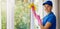 Smiling woman janitor in blue uniform clean a house. cleaning services. banner with copy space