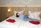 Smiling woman joyfully raised her hands on the bed in a hotel room, vacation concept