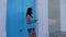 Smiling woman knocking in blue arabian door and holding phone. Woman rat tat tat to door