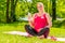 Smiling woman in late pregnancy does yoga