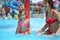 Smiling woman and little girl bathes in pool