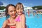 Smiling woman and little girl bathing in pool