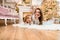 Smiling woman and little girl lie on floor with their hands on their heads