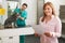 Smiling Woman Looking At Bill In Veterinary Surgery