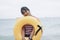 Smiling woman looks bright. In the yellow rubber donut ring standing on the beach behind the sea. Sunny summer