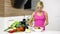 Smiling woman mixing a salad in her kitchen