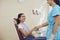 Smiling woman patient shaking hand to dentist after successful tooth examination in dental clinic
