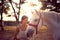 Smiling woman pets her white horse. fun on countryside,  golden hour. Freedom nature concept