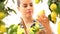 Smiling woman picks a lemon and put it in the basket