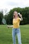 Smiling woman playing badminton game in park, summertime concept