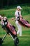 smiling woman in polo and cap with golf gear at golf course