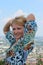 Smiling woman posing in front of camera on the city roofs background