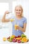 Smiling woman pouring fruit juice to glass at home