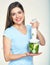 Smiling woman prepairing green smoothy in blender.