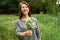 Smiling woman presents a bouquet of daisies