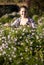 Smiling woman pruning flowers at garden with shears