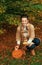 Smiling woman putting candle in carved Halloween pumpkin