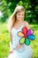 Smiling woman with a rainbow flower outdoors