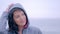 Smiling Woman in raincoat on gray rainy beach