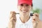 Smiling woman in red cap holding key and keyhole closeup