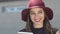 Smiling woman in red hat reads something in her tablet