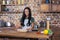 Smiling woman rolling pizza dough in kitchen