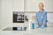 Smiling woman in rubber gloves ready for clean up in the kitchen. Detergents, sanitizer spray and gel in bottle on the