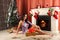 Smiling woman in santa helper hat over living room with christmas tree background