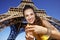 Smiling woman showing hashtag gesture against Eiffel tower