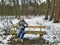 Smiling woman sit on bench snowy winter forest