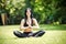 Smiling woman sits in lotus position zen gesturing.