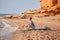 Smiling woman sitting on surfboard in bikini ready to catch wave. Hot summer holiday, beach relax and adventure concept