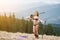 Smiling woman skier enjoying warm spring, wearing swimsuit, boots and sunglasses