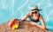 Smiling woman in straw hat in sunglasses swimming in pool and enjoying fresh tropical fruits