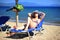 Smiling woman suntanning on a sunbed at the beach